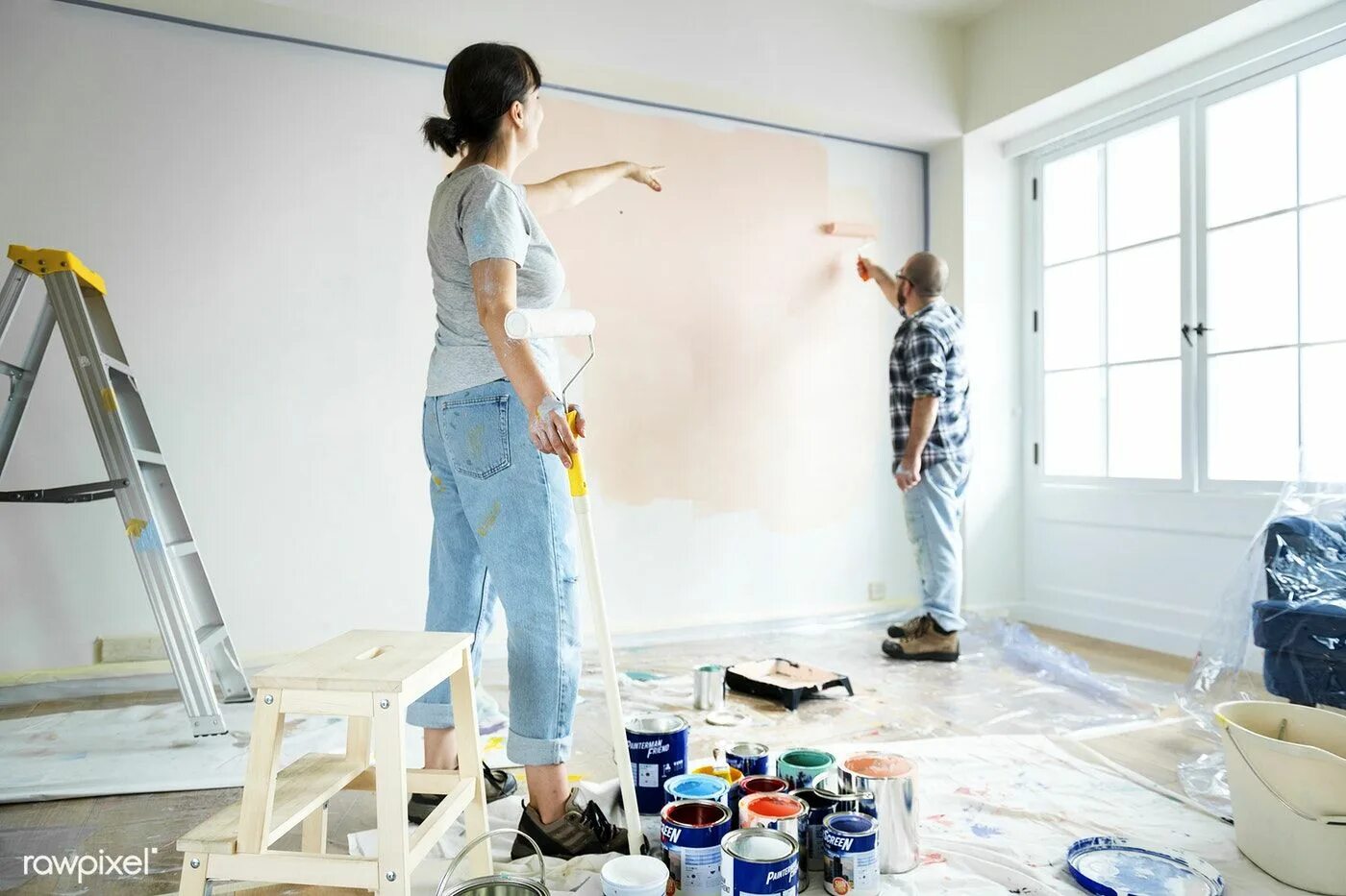 Following a recent renovation the new. Делают тремонт в квартире. Home renovation services. Renovation. Человек красит стену.