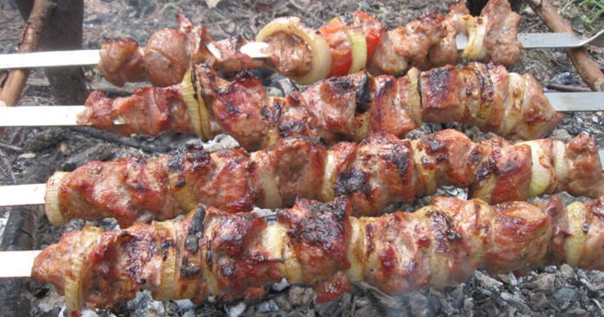 Шашлык горит. Сухой шашлык. шашлык с помидорами и луком на шампурах.