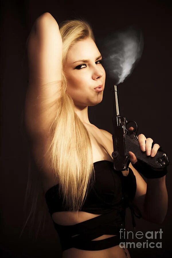 Рука с пистолетом. Девушка дует на дуло пистолета. Ствол направленный в камеру. Дует на дуло пистолета. Рука с пистолетом.