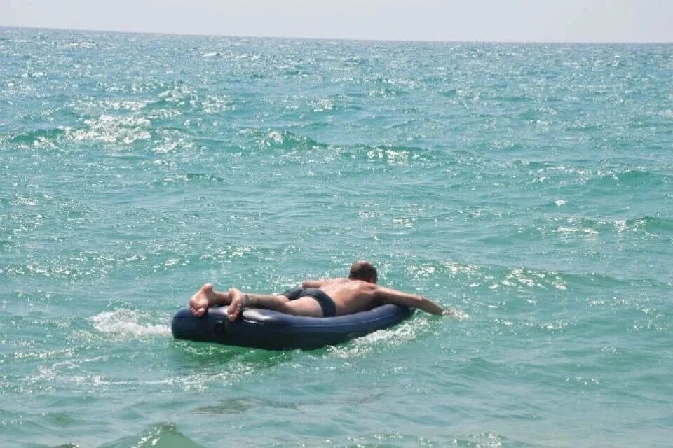 В черном море можно плавать. Мужик на матрасе в море. купание в море. плавают на матрасе. человек на надувном матрасе.