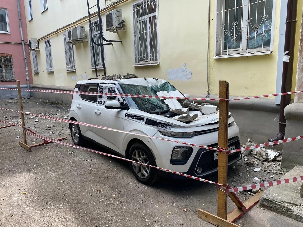 Машина во дворе. Припаркованная машина. Машина на кирпичах. Городской автомобиль.