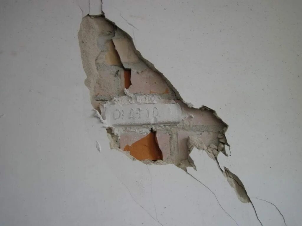 Ремонт трещин в стенах. Оштукатуривание стен дефекты. Шпаклёвка для трещин в стене. Стена с обвалившейся штукатуркой. Штукатурка дыр в стене.