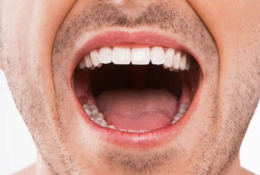 Стоит с открытым ртом. Хорошие зубы. Здоровые зубы открытый рот.