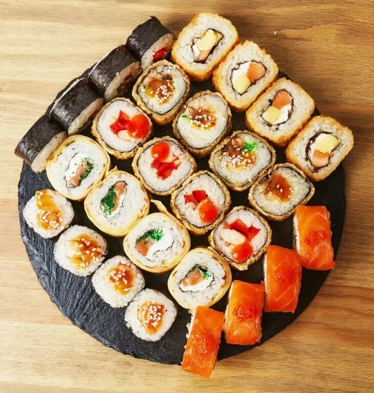 роллы вкусно и точка. вкусные суши. роллы на черном фоне. ролл со сливочным сыром и лососем в масаго. ролл филадельфия эбби.