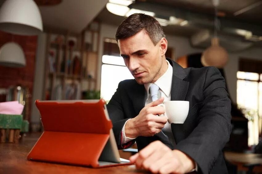 Бизнесмен в кафе. Бизнесмен в кафе. Бизнесмен в кофейне. Бизнесмены на переговорах в ресторане. Мужчина ждет за столом.