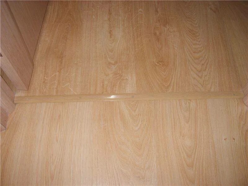 Стык ламината между комнатами. Укладка ламината стык. Стык линолеума в дверном проеме. Стык ламината. Ламинат без стыков.