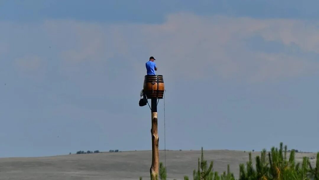 Человек сидит на столбе. Человек облокотился на дерево. Парень опирается о дерево. Человек сидит на столбе. Человек сидит на столбе.