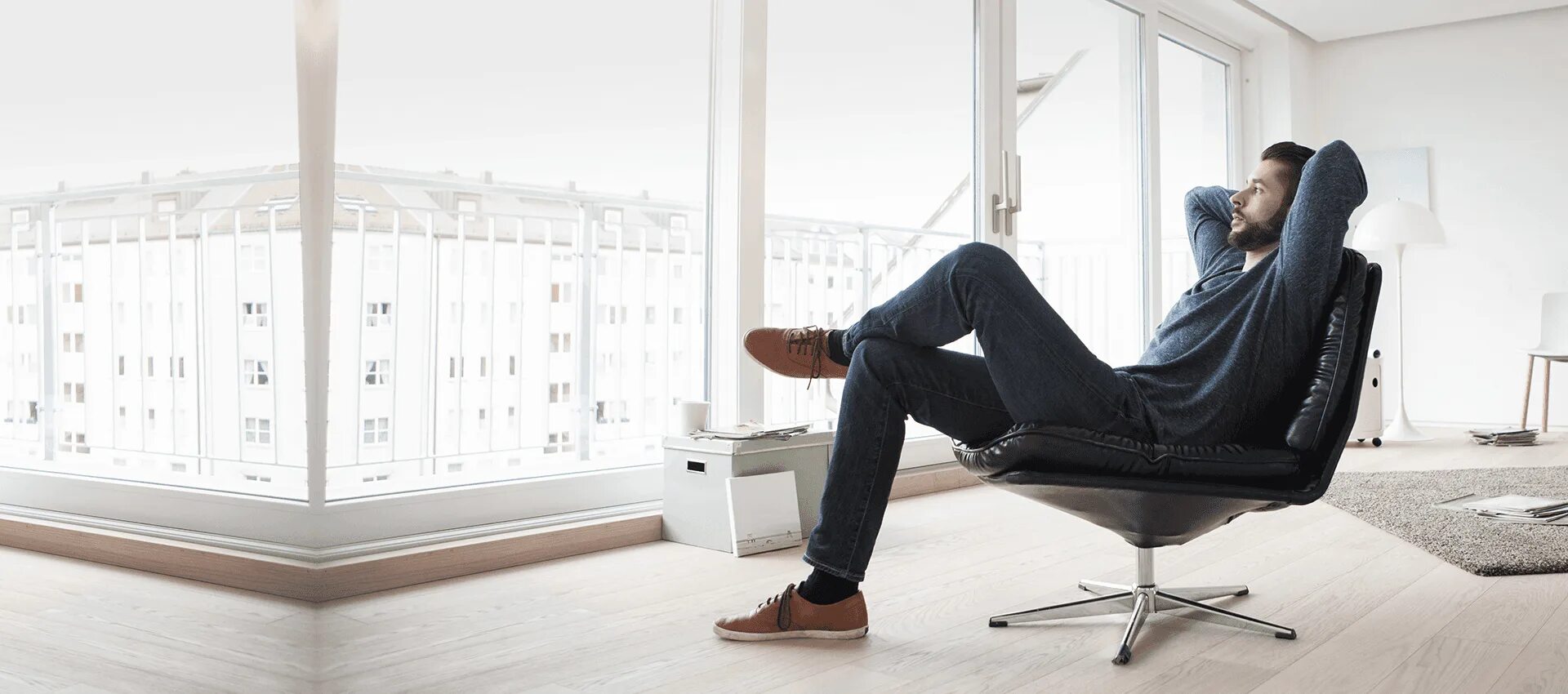 The windows is the sofa. Comfort man. man on arm chair. man sitting on sofa. man relaxing on sofa at home.