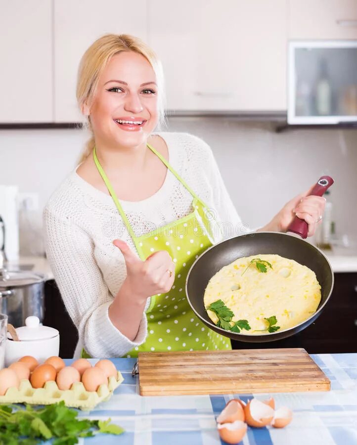 Девушка готовит омлет. Девушка ест омлет. Женщина готовит яичницу. Современная женщина на кухне омлет.
