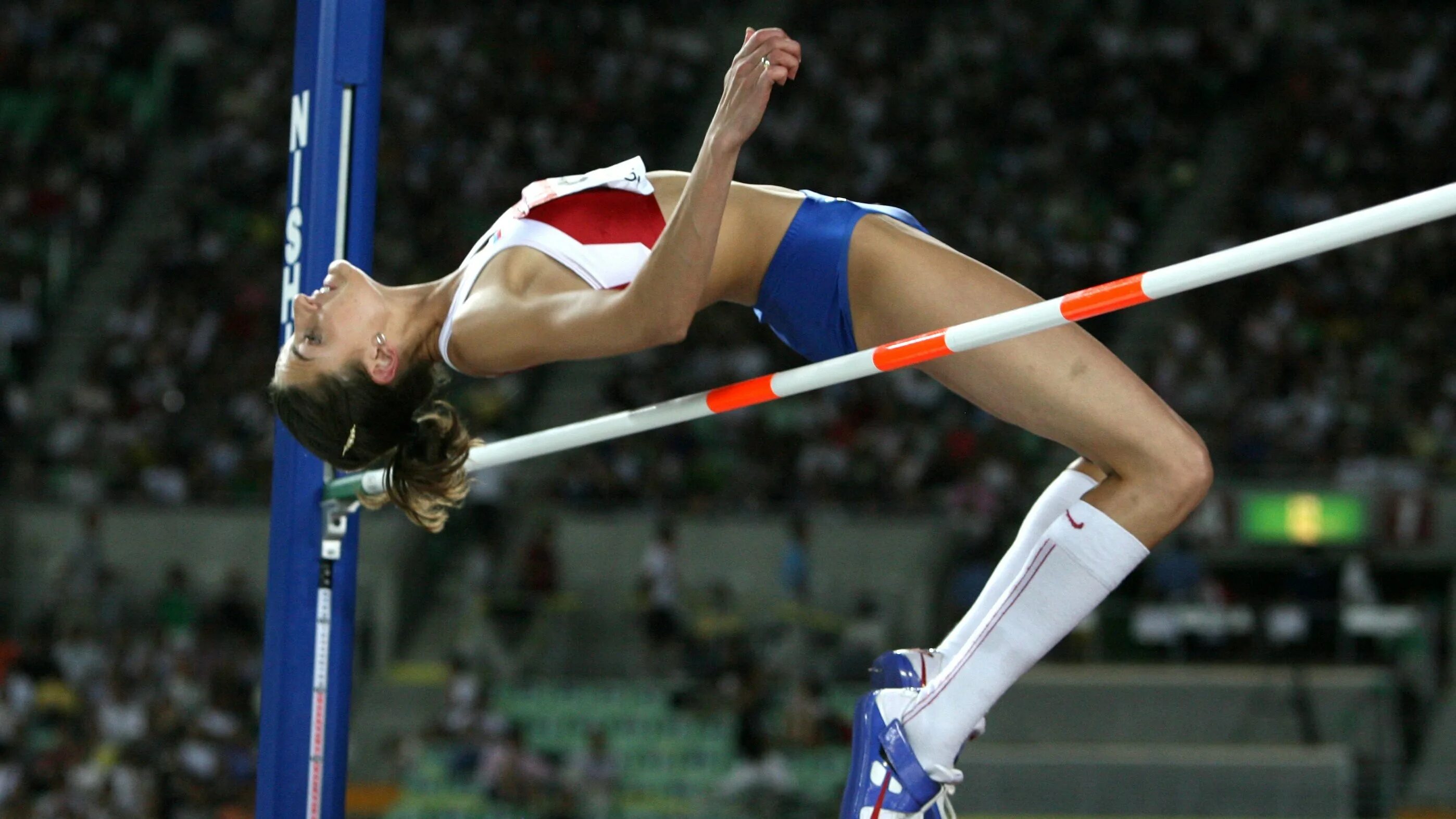 Прыжок через планку ножницами. Через планку. Фосбери-флоп в легкой атлетике. Прыжки в высоту. Через планку.