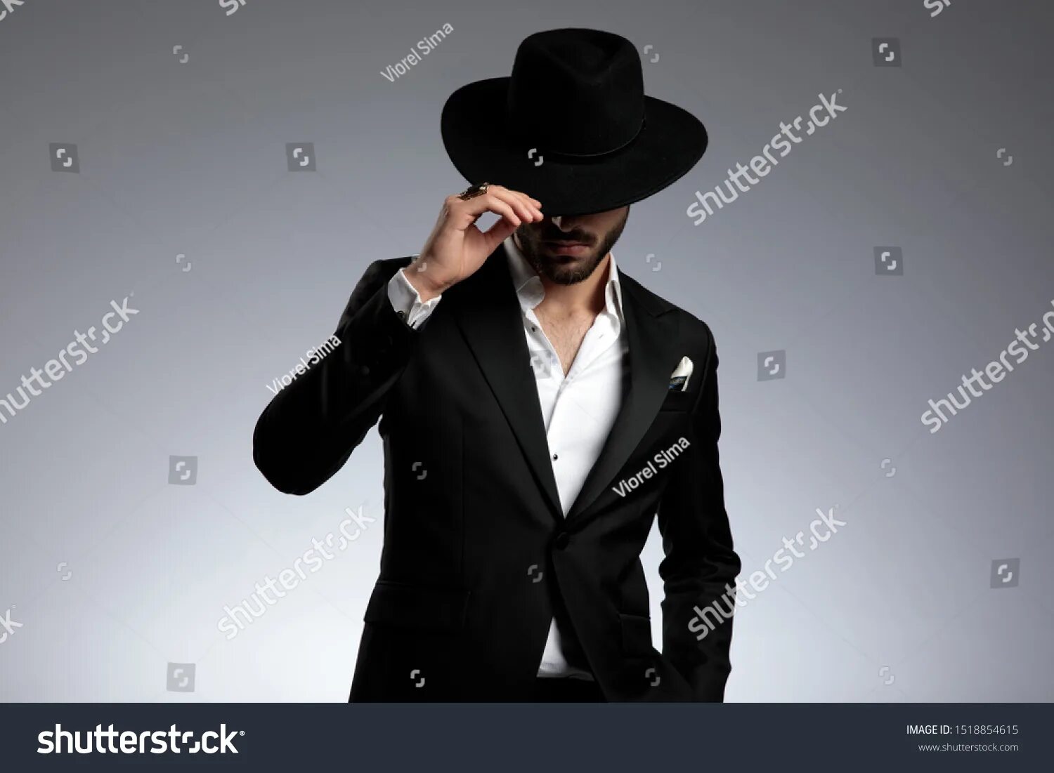 Мужчина в шляпе серый фон. Мужчина в котелке. Снимаю шляпу.