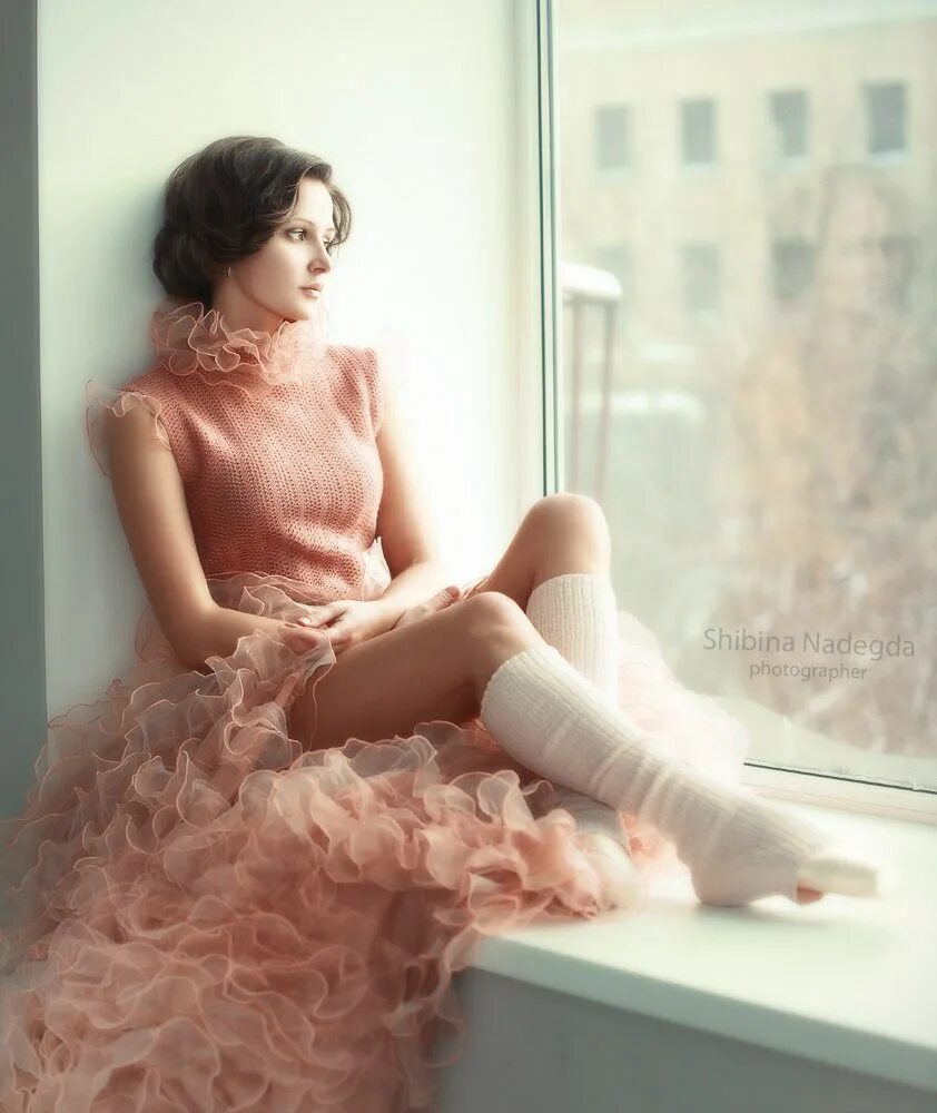 это женщина в окне в платье розового