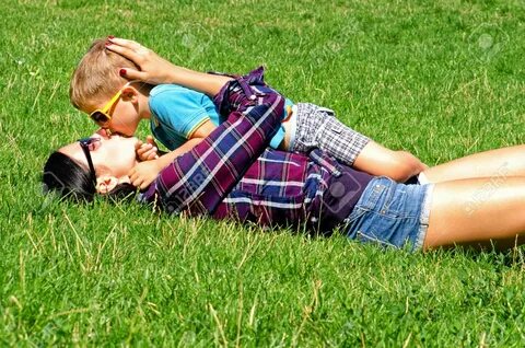 Jeune maman et son fils baiser couché sur la pelouse - 37443601.