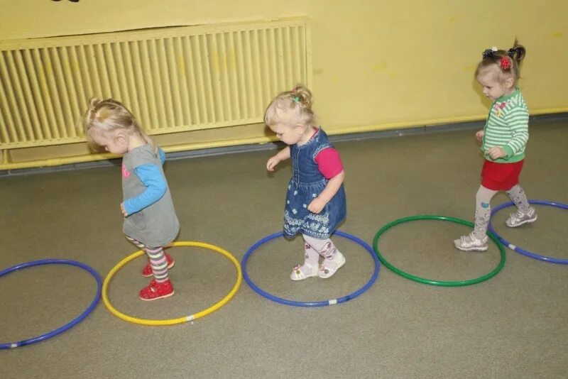 Упражнения с обручами в детском саду. Обручи для детей раннего возраста. Упражнения с обручем для малышей. Дети на занятии в детском саду. Физкультурное в первой младшей группе