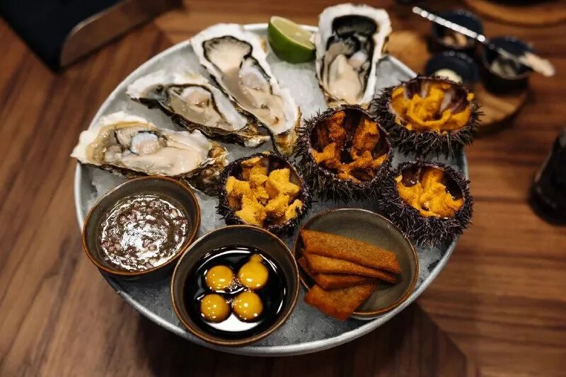 морской еж моремания. морские ежи и устрицы плато. морские ежи и устрицы в ресторане. морские ежи и устрицы. морской еж в ресторане.