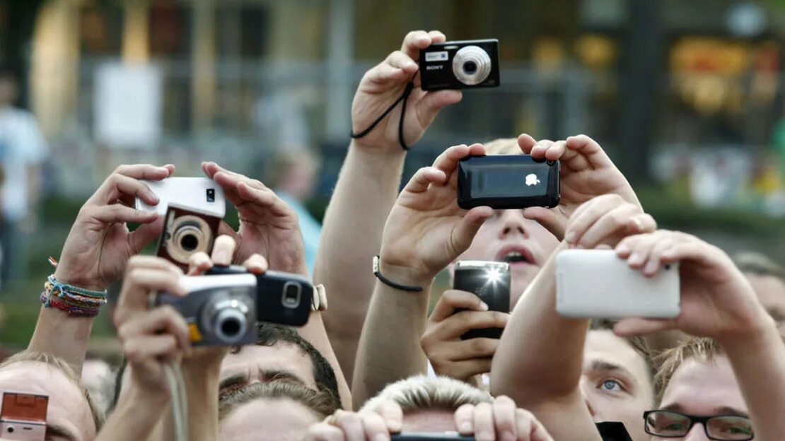 Человек фоткает. Человек фотографирует на телефон. Люди фотографируются. Человек с камерой.