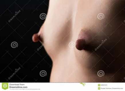 Photo about Pretty small breasts with large nipples closeup. 