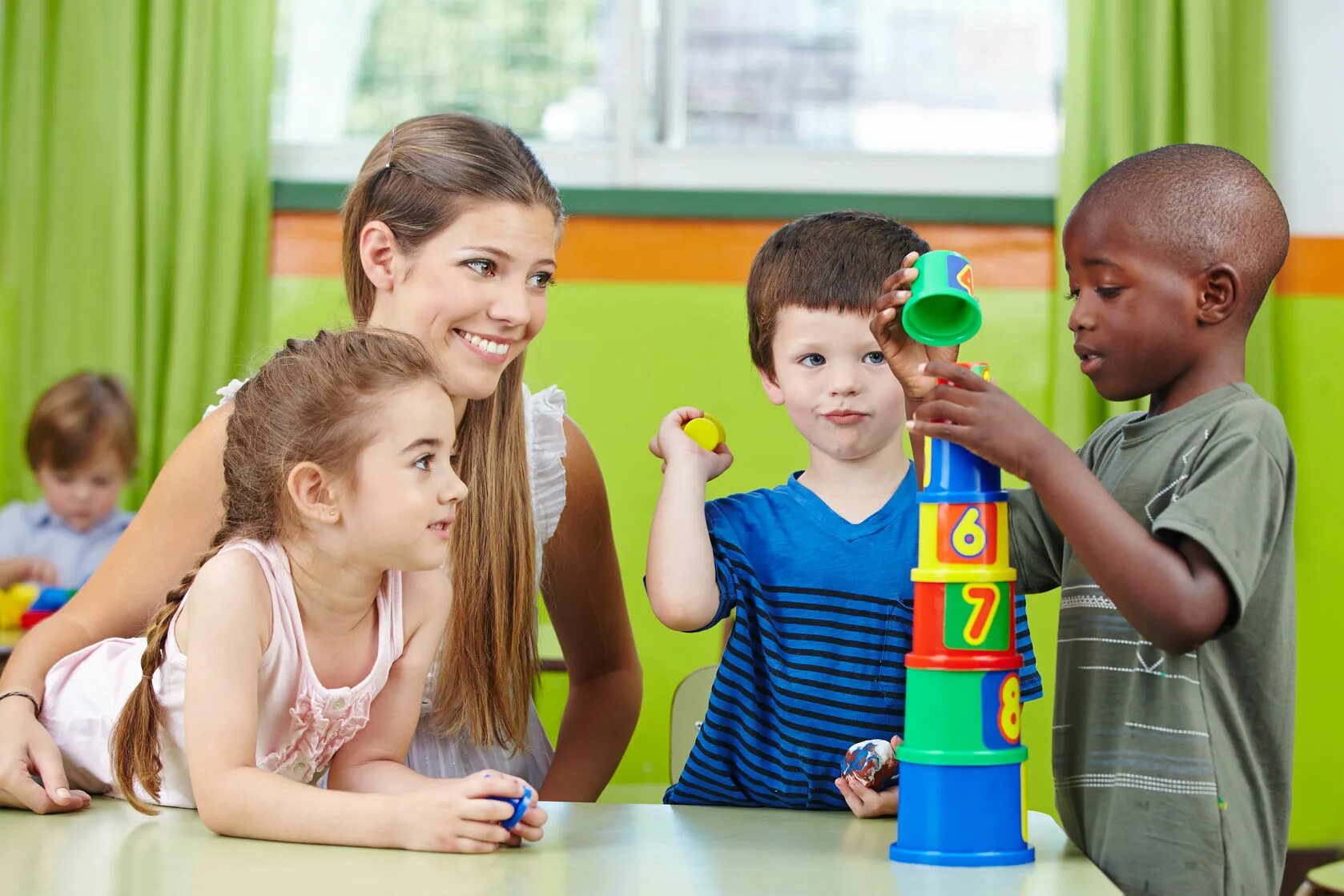 Preschool teachers. Дошкольное образование в Великобритании. Детский сад в Америке. Играющие дети с педагогом. Воспитание.