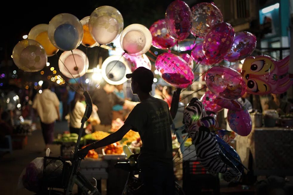 Продавец воздушные шары. Продавец воздушных шаров. Продавщица воздушных шариков. Торговля шарами на улице. Праздник на улице с шарами.