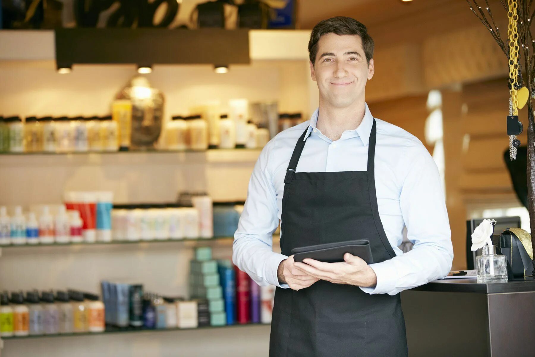 He work in a shop. Продавец мужчина. Продавец консультант мужчина. Управляющий магазином. Менеджер магазина.