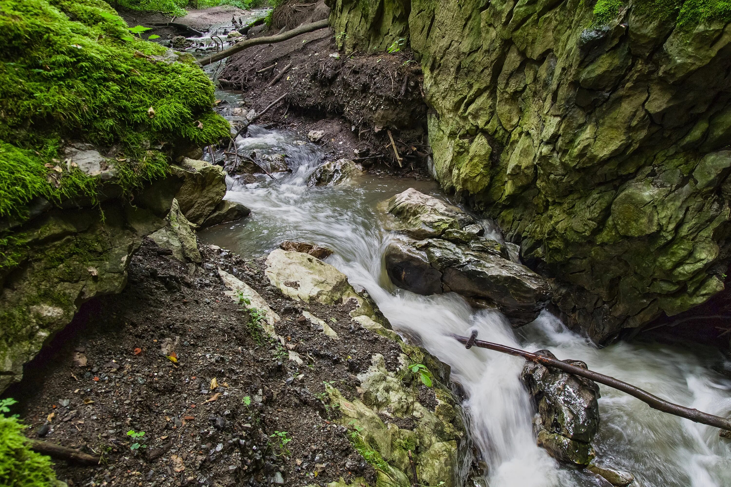Река широкая а ручей. Ручей водопад. мокрые скалы. водопад в горах. проточная река.