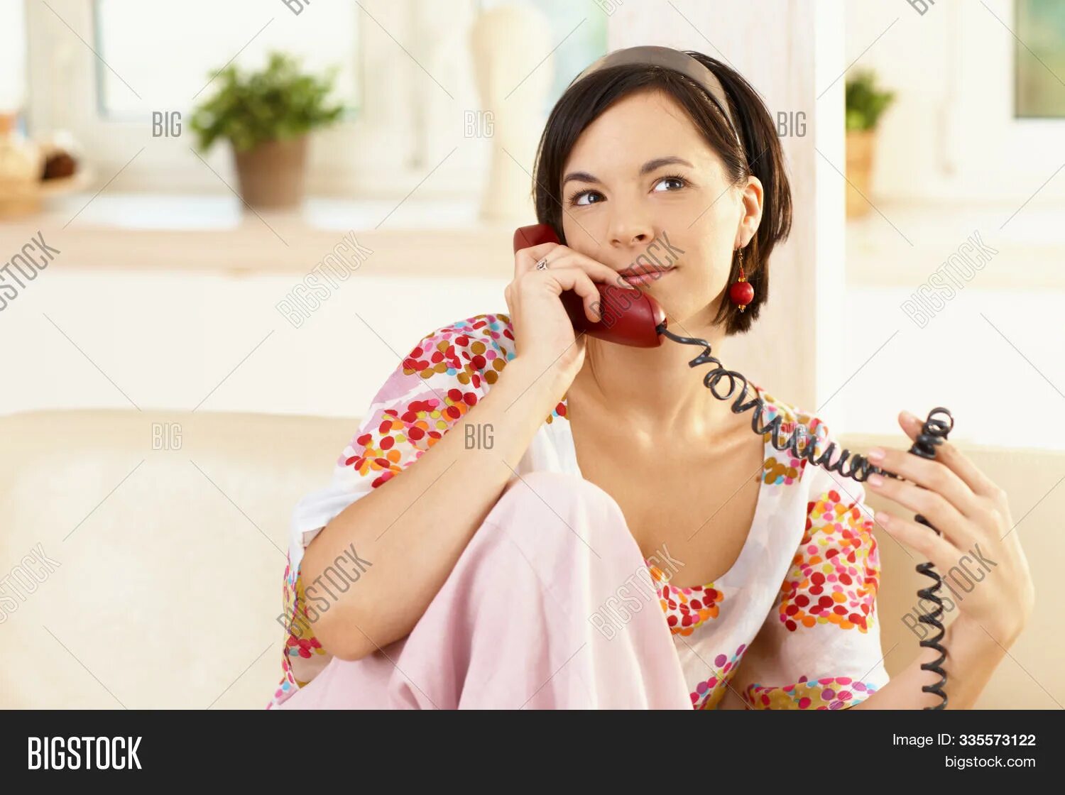 Женщина говорит по телефону. Женщина звонит по домашнему телефону. Говорит по домашнему телефону. Женщина говорит по телефону домашнему. Жена разговаривает по телефону а ее