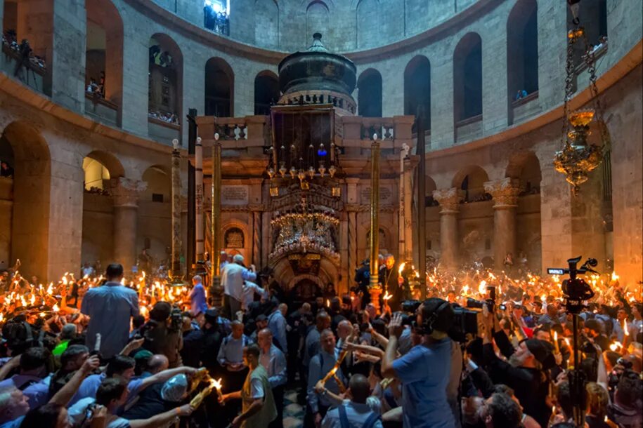 Схождение благодатного огня в иерусалиме 2022. Благодатный огонь на пасху. Храм гроба господня на пасху. Благодатный огонь 2022. Умывание благодатным огнем иерусалим.