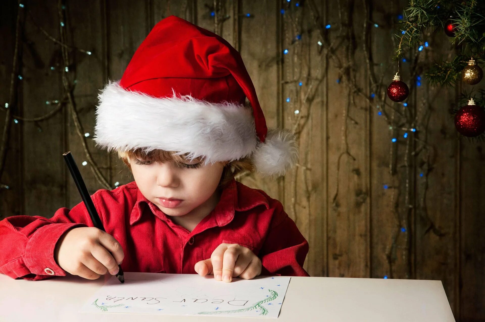 Новый год дети. Ребенок пишет письмо деду Морозу. Новогодний мальчик. Мальчик в новогодней шапке. Елки письмо
