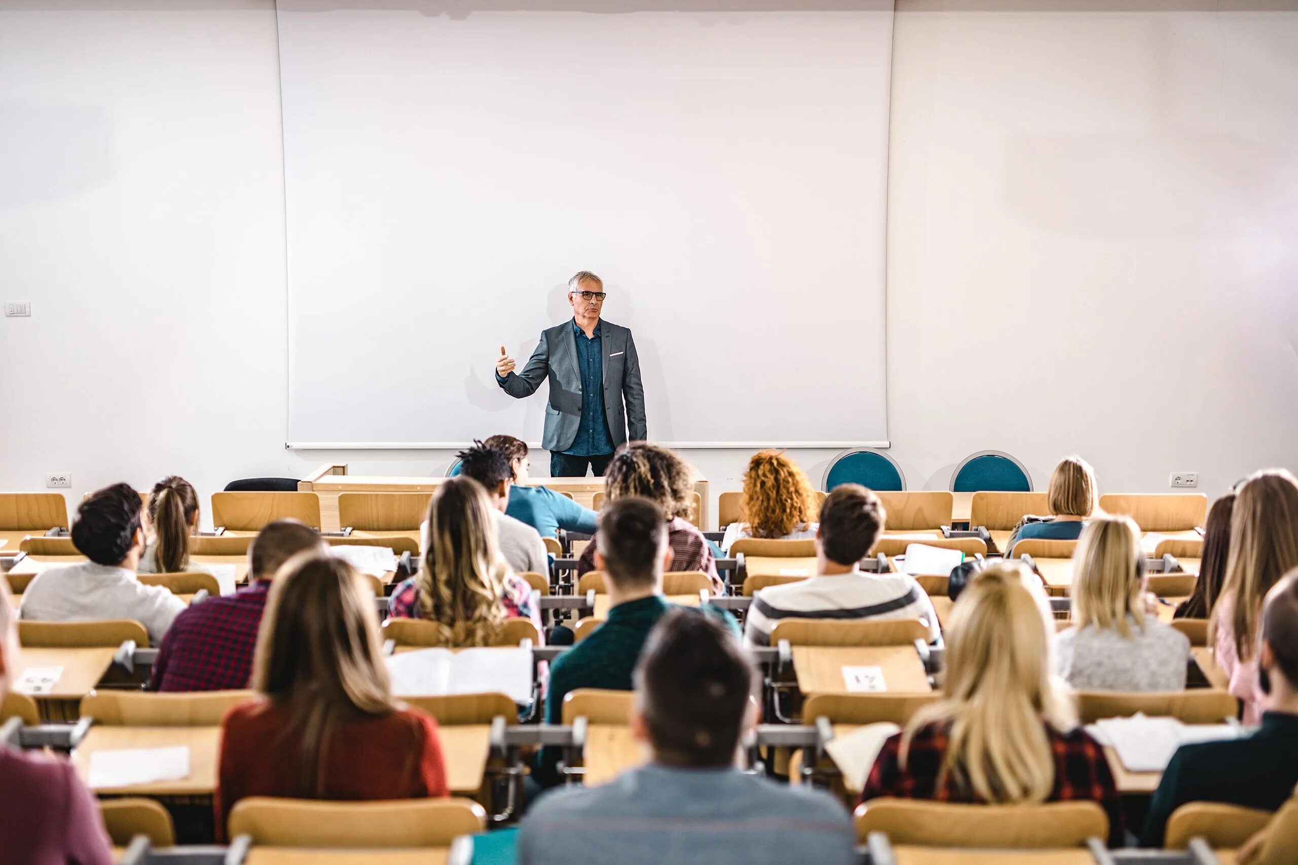 Лекция в аудитории. Студенты в аудитории. Лекция в университете. Преподавание в вузе.