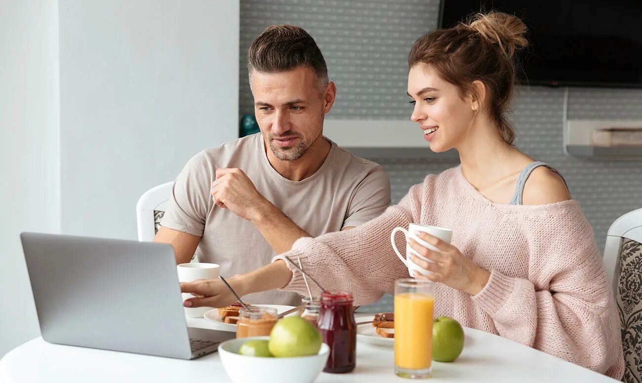 Talking at the Kitchen. Business couple Breakfast. Desayunando. Have Breakfast and watch youtube photo.