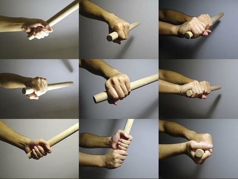 Человек держит биту. Бита в руке. Рука держит барабанные палочки. Палочки для биолокации. Человек две палки.