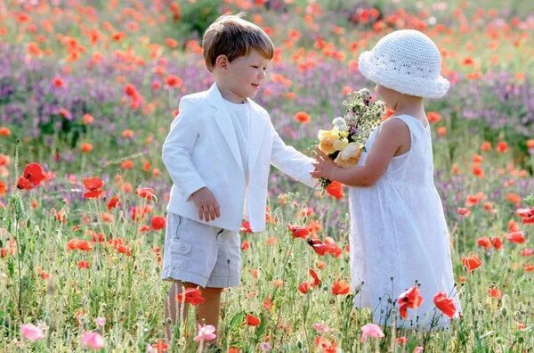 Жить нужно для детей. Мальчик дарит девочке цветы. Мотиватор доброта. Доброта и любовь. Мальчик дарит девочке ромашки.