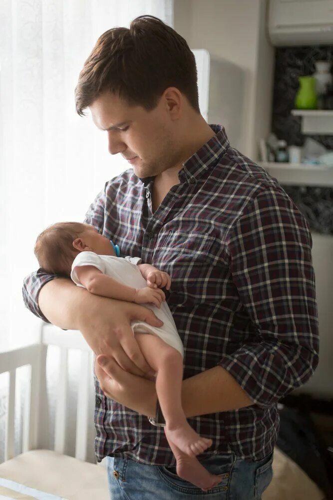 Мужчина с ребенком на руках. Мужчина с младенцем. Мужчина держит новорожденного.