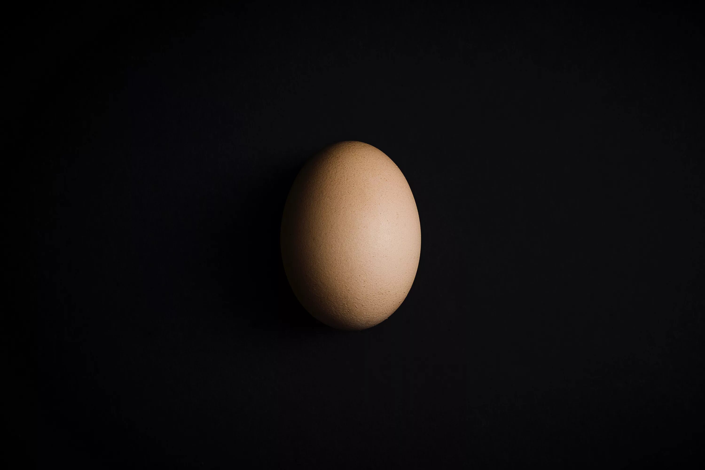 Яйцо стало черным. Яйцо куриное. Куриное яйцо на черном фоне. Яйцо на темном фоне.