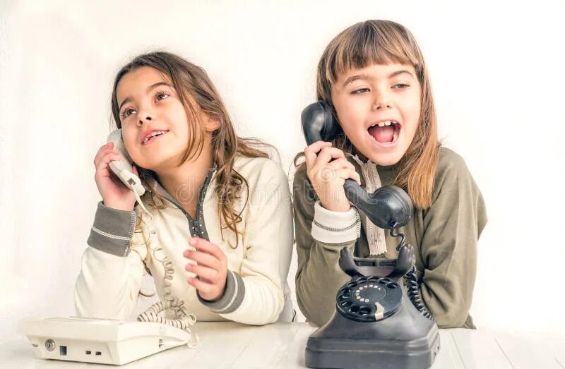 Пока дочь разговаривает по телефону. Две девочки с телефоном. Две девушки разговаривают по телефону. Две подруги разговаривают по телефону. Подружки болтают по телефону.