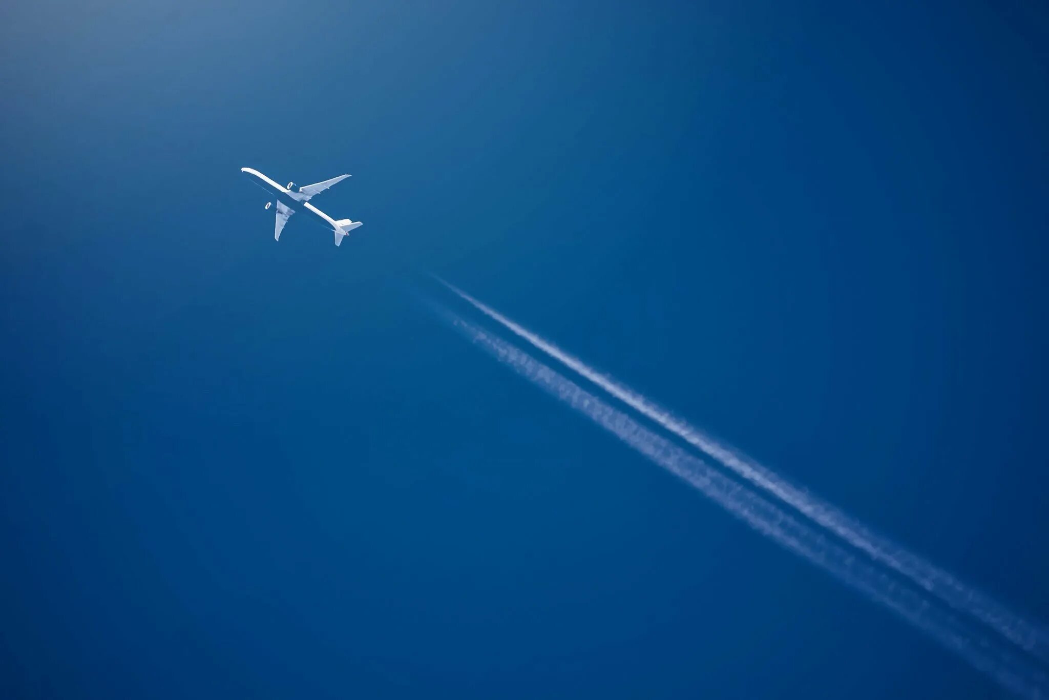 Самолет в небе. Самолет снизу в небе. Самолет в небе сверху. След самолета. За пролетающим самолетом видна темная полоса