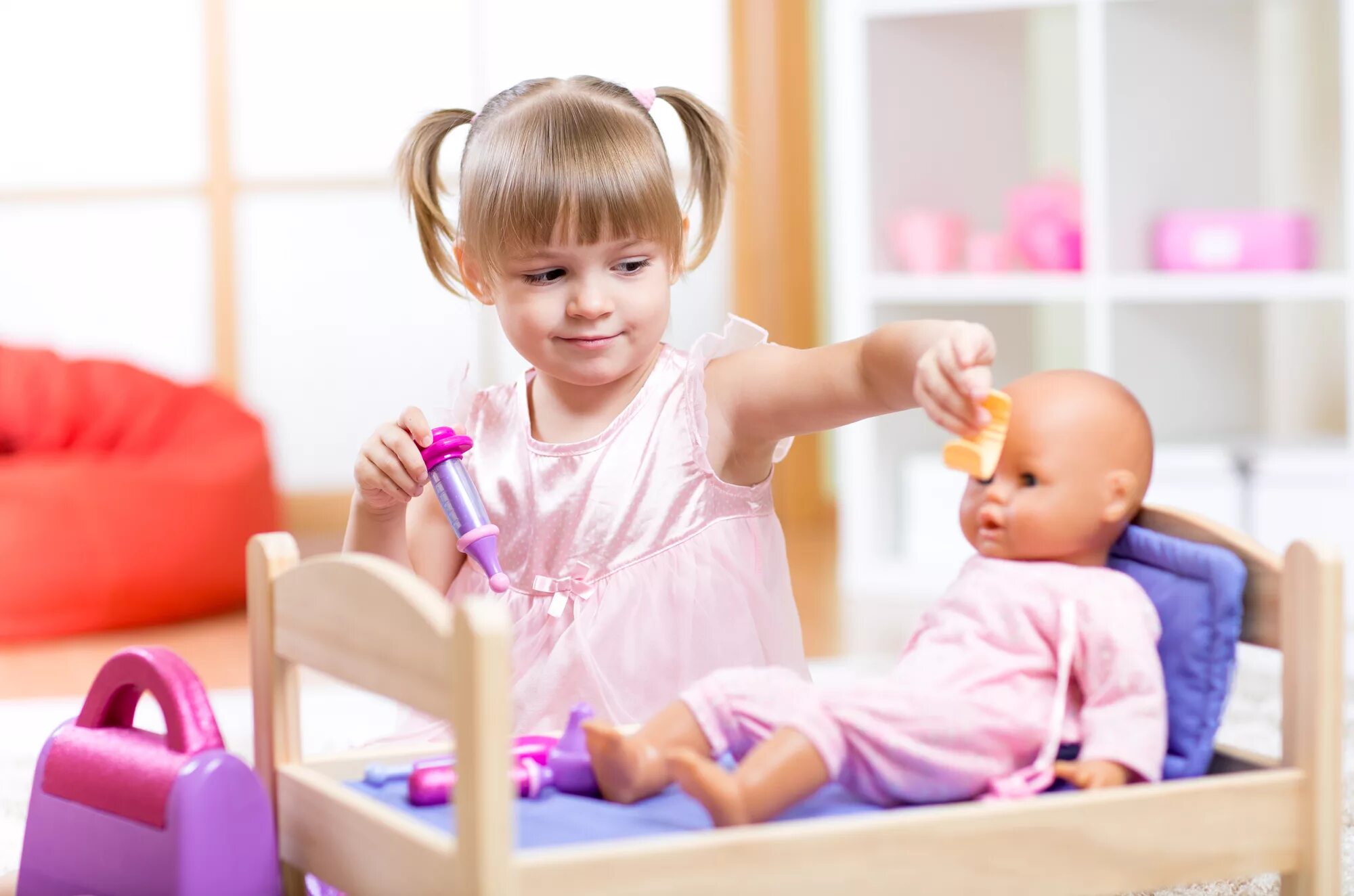 Девочка играет маленькими игрушками. Девочка играет в куклы. Маленькая девочка играет с куклой. Мальчик играет в куклы. Ребенок играющий в куклы.
