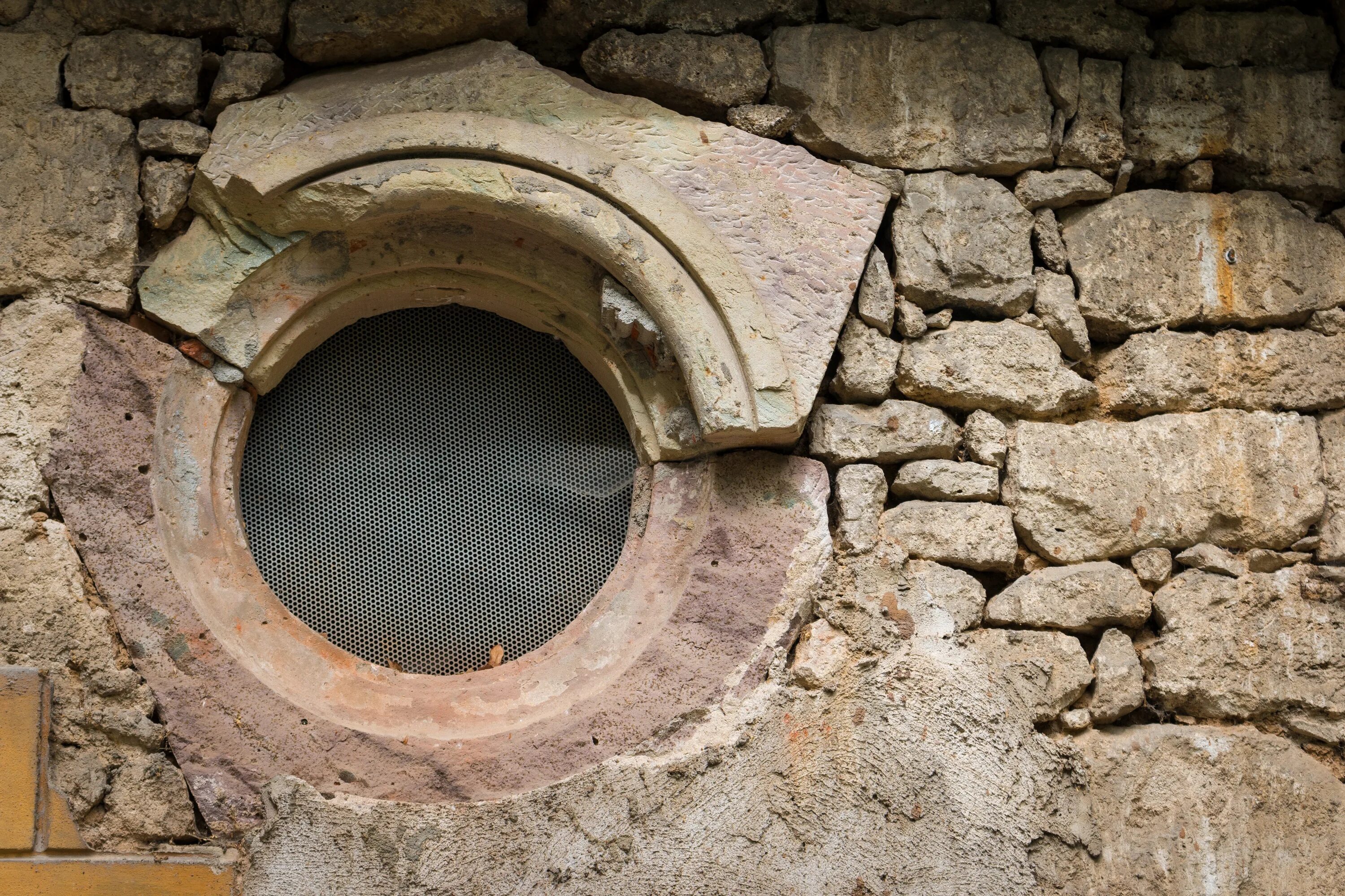 В стене дыра в дыре глаза. Древние круглые окна. Дыра в каменной стене. Окошки древние каменные. Круглое окно в каменной стене.