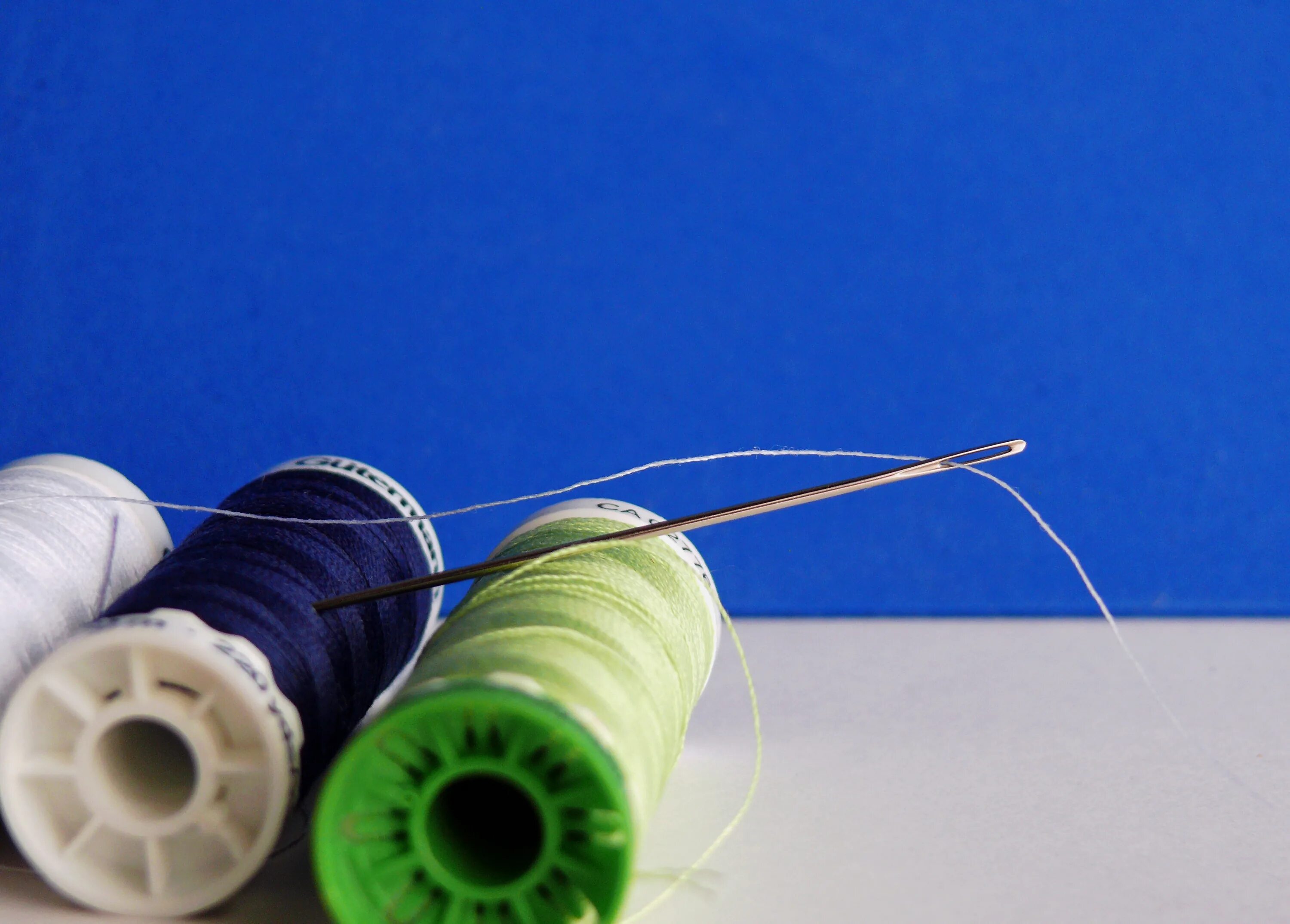 Вдевание нитки. Иголка с ниткой. Нитки для шитья. Игла с ниткой. Моток ниток для шитья.