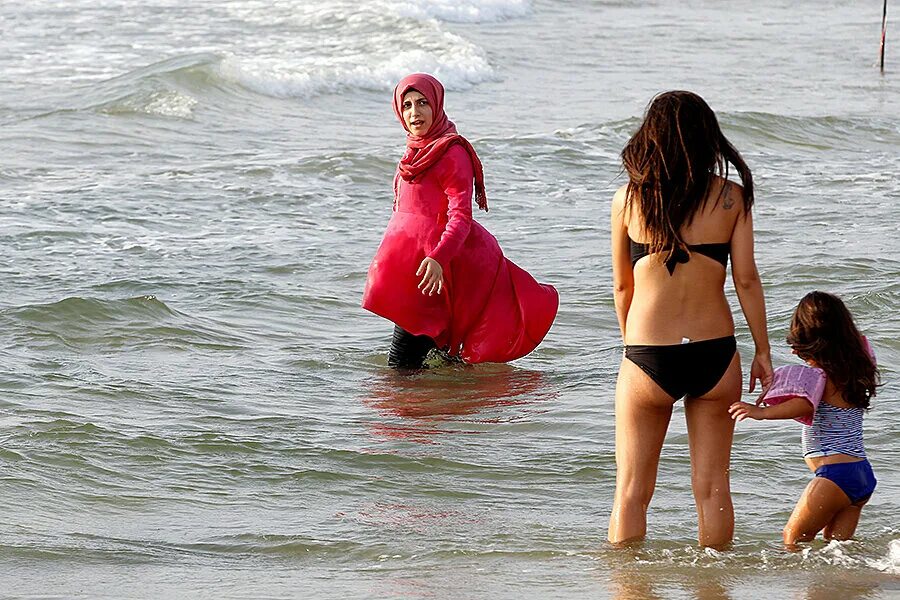 Буркини Иран. Арабские женщины на пляже. Мусульманка на море. Мусульманки купаются в море.