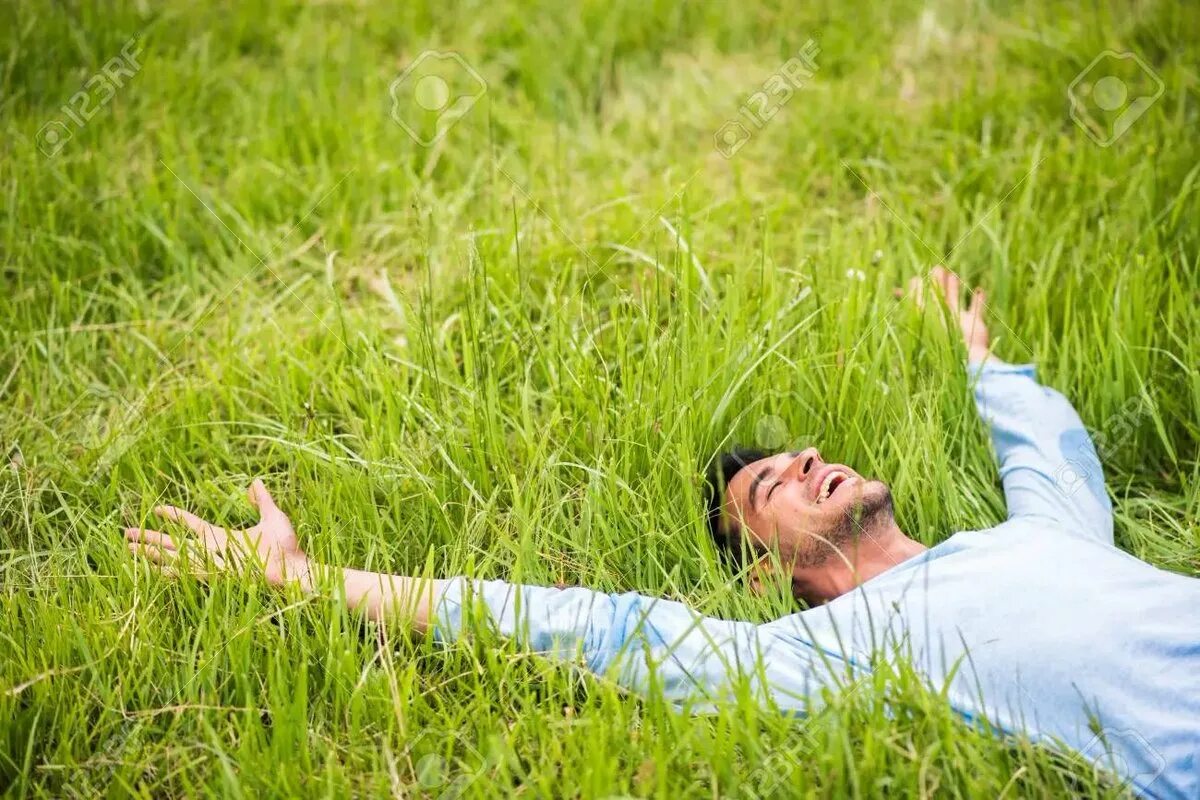 Примыкающий человек. Лежит на траве. Человек лежит на траве. Парень в траве.