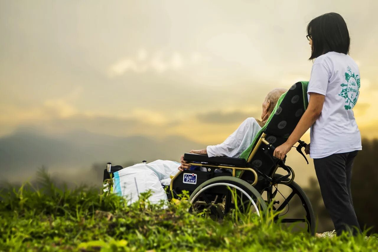 Мужчина опекун. Люди с ограниченными возможностями. Инвалиды на природе. Человек в инвалидной коляске. Инвалидная коляска на природе.