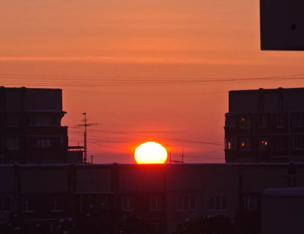 Ночной город с крыши. Крыши многоэтажных домов. Закат из окна многоэтажки. Полет в облаках. Закат многоэтажки.