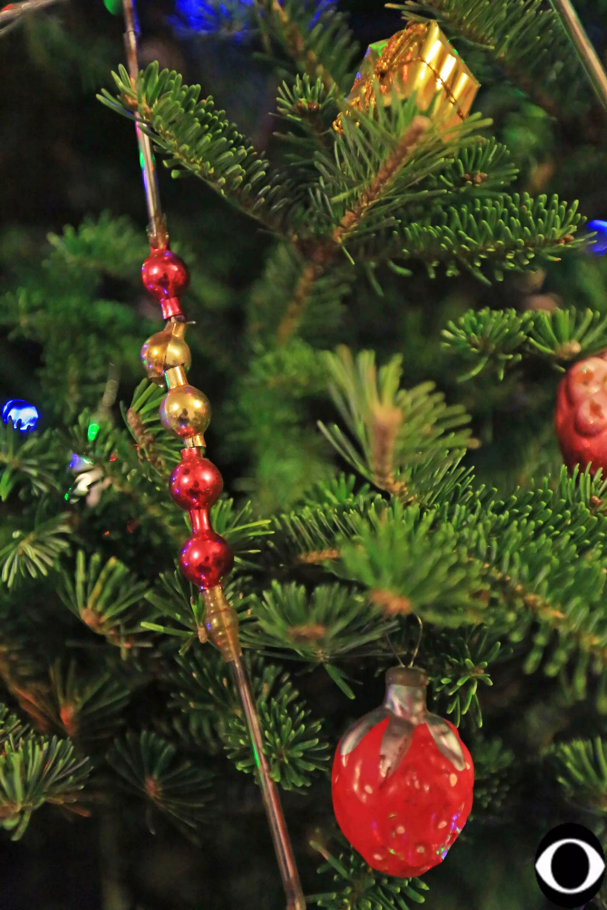 как вешать новогодние бусы. бусы на елку. новогодние бусы в интерьере. елка с игрушками. круглые красочные украшения развешанные на елках.