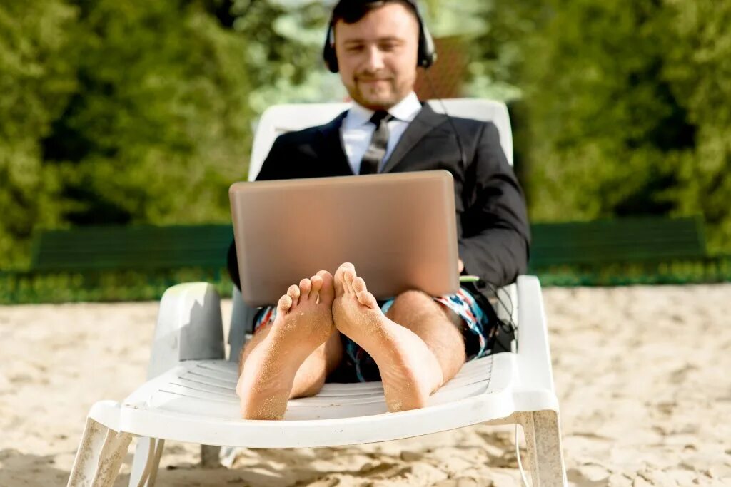 Работа вне учреждения. Бизнесмен в отеле. Бизнесмен на пляже с ноутбуком. Мужчина с ноутбуком. Предприниматель на отдыхе.