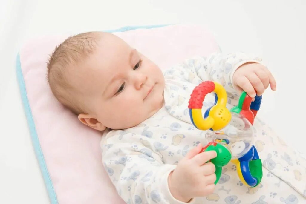 На работу в 4 месяца ребенку. Погремушка для детей. Младенец с погремушкой. Игрушки для малышей 6 месяцев. Игрушки для малышей до года.