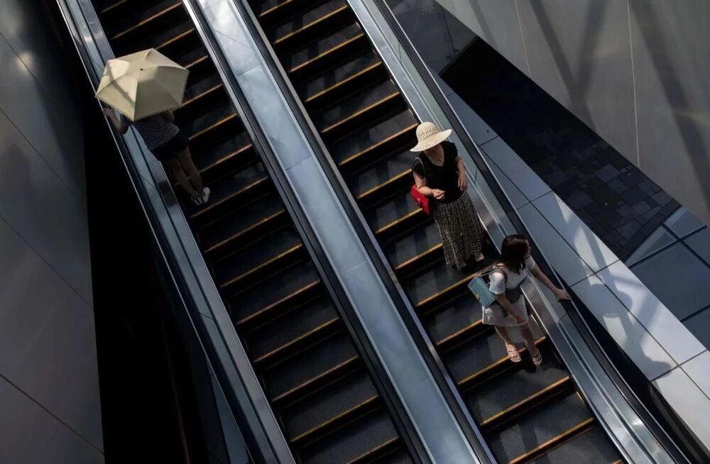 Эскалатор метрополитена поднимает стоящего. Люди на эскалаторе. Съемка на эскалаторе. Фотосессия на эскалаторе. Фотосессия моделей на эскалаторе.
