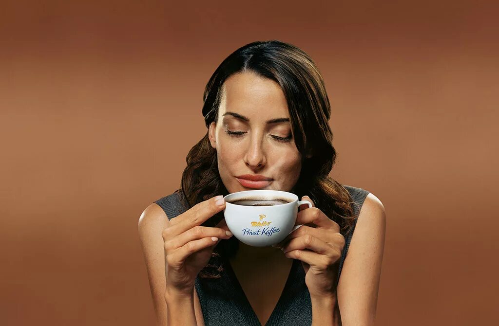 Рекламирует кофе. Реклама кофе. Девушка пьет кофе. Наслаждение кофе. Девушка рекламирует кофе.