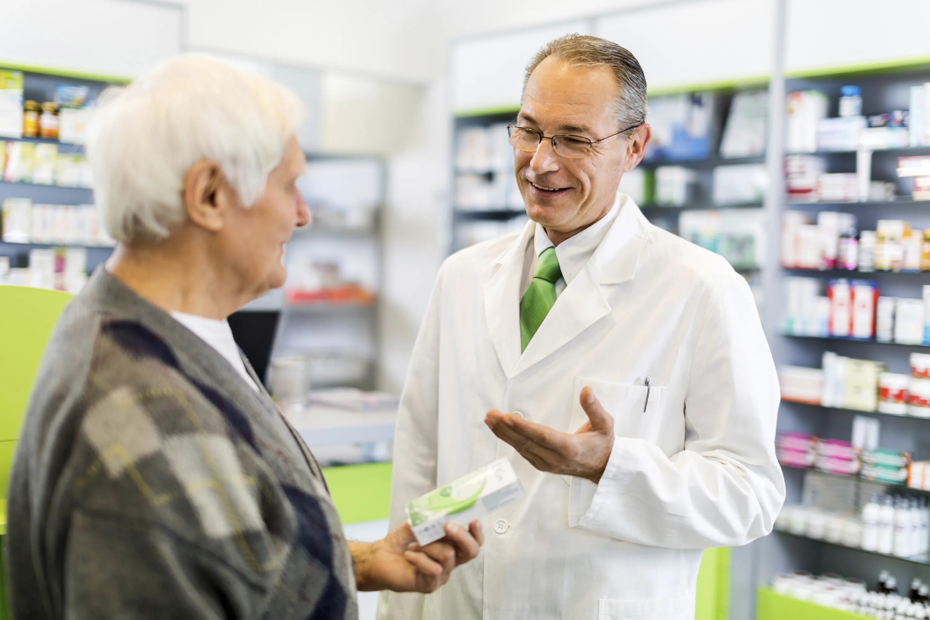 выкладка лекарств в аптеке. девушка выбирает лекарства. провизор в аптеке.