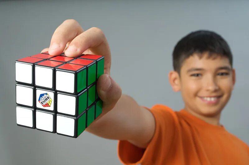 Рубиком фото. Кубик Рубика в руках. Ребенок и кубик Рубика. Мальчик с кубиками. Рука держит кубик Рубика.